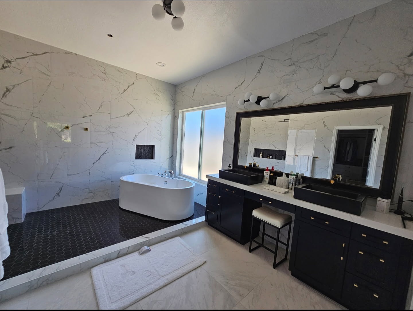 Luxury bathroom remodel with frameless shower, marble tiles, and modern vanity